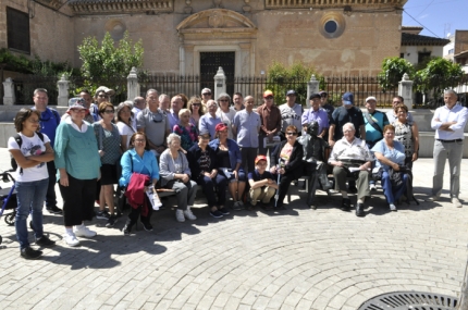 El grupo junto a autoridades municipales y miembros de la fundación posa con la estatua de Francisco Carvajal en la plaza de España