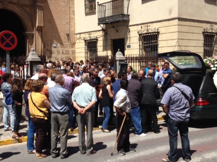 El féretro es portado por amigos y familiares a la salida del templo