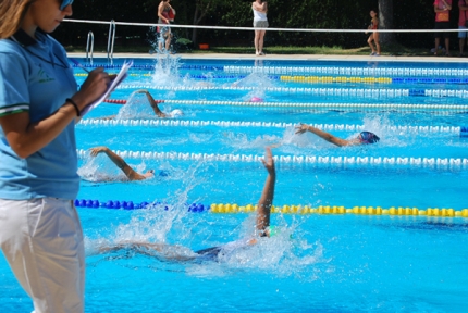Un grupo de nadadores durante una de las series del 4x50 estilos seguido por los jueces. 