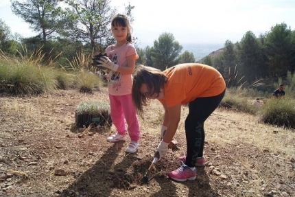 Dos niñas participan en la jornada del día del árbol 