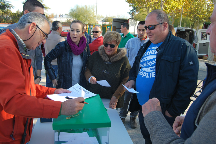 Uno de los miembros del grupo motor aitende a los votantes en la urna instalada en el mercadillo 