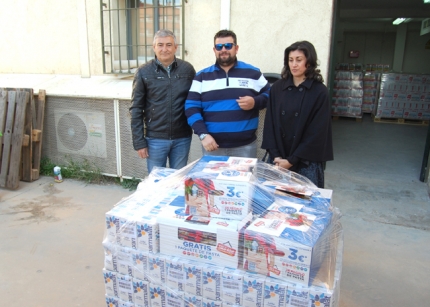 Diego Valero, concejal de Deportes, Francis Cortacero, organizador del Mundialito y Rosa Ruz de Cruz Roja, frente a un palet de alimentos.