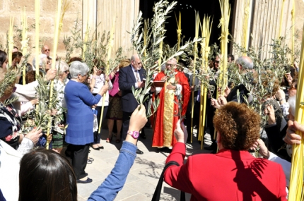 El párroco bendice las palmas y ramas de olivo antes del inicio de la procesión.