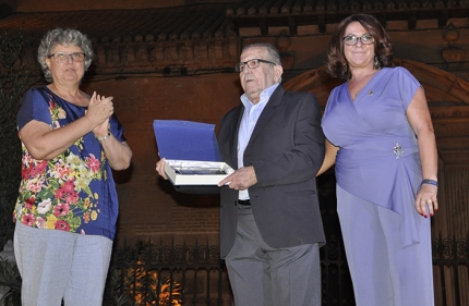 El pregonero recibe un placa flanqueado por la alcaldesa y la concejala de Fiestas. 
