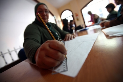 Una inmigrante rellenando unos papeles 