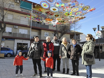 Vecinos de la asociación `Culillos de mal asiento` posan en la plaza bajo la decoración con material reciclado.