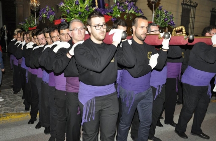 Grupo de costaleros de la hermandad el Viernes Santo portando el trono del Nazareno a la salida de la iglesia de Albolote