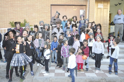 Niños y mayores posan frente a la biblioteca de El Chaparral disfrazados de personajes de miedo.