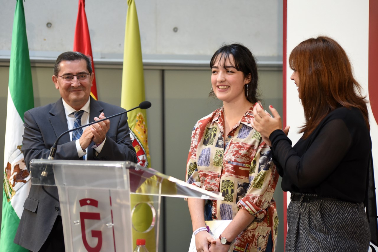 Sara Morillas recibe el apluado del presidente de Diputación y la delegada de Iguadad en el acto de entrega del premio de microrrelatos. DIPUTACIÓN 
