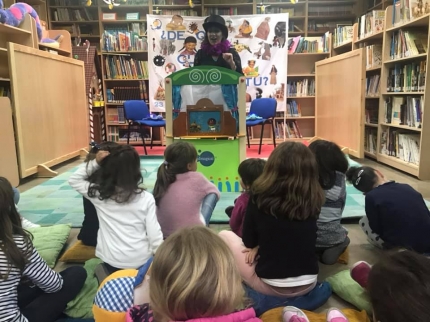 Un grupo de niños y niñas participa en el cuentacuentos de la biblioteca 