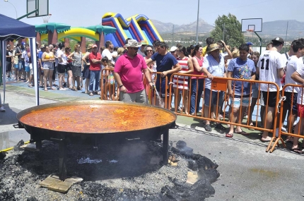 Vecinos de la urbanización El Torreón guardan cola para degustar la paella a mediodía.