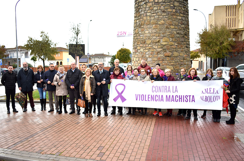 Representantes municipales y de los colectivos sociales posan con una pancarta contra la violencia machista al terminar el izado de la bandera