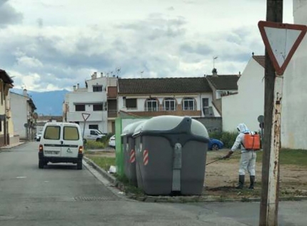 Un operario municipal desinfecta uno de los contenedores grises del municipio.