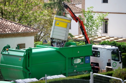 Un camión-pluma recoge un contenedor amarillo en una de las urbanizaciones de Albolote el 15 de abril