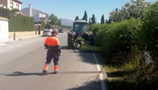 Un tractor con un brazo mecánico desbroza las cunetas del Camino de Albarrate en las urbanizaciones de la falda de la sierra