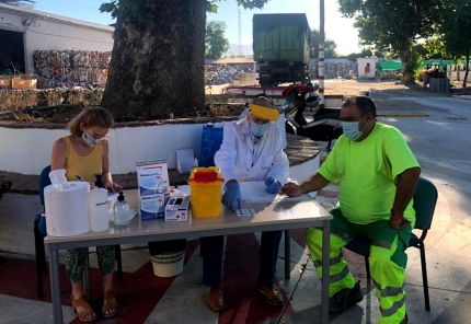 Prueba del Covid a uno de los trabajadores bajo el gran platanero que hay en el patio principal de La Cartuja