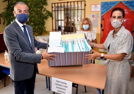 Damian entrega el lote de mascarillas a la directora del Tínar, Pilar Martínez, en presencia de la concejala de Educación, Carmen Calderay