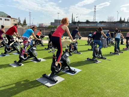 Participantes en una clase de ciclo outdoor en la zona de césped artificial