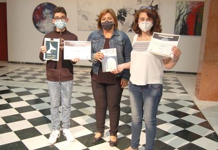 La concejala Toñi Guerrero entrega los premios del concurso de relatos. Abajo, ganadores del concurso de cruces y trajes flamencos.