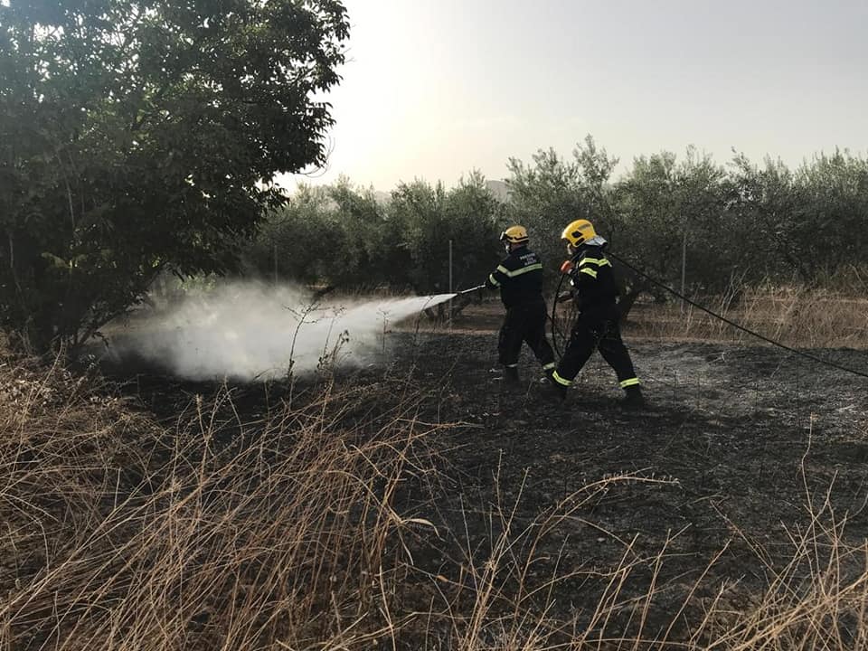 Voluntarios de Protección Civil en una extinción de un conato de incendio en una zona de pastos 