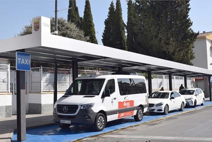 La nueva parada de taxi de Albolote en la avenida Jacobo Camarero. Abajo, acto de inauguración con el alcalde, concejales y taxistas del municipio.