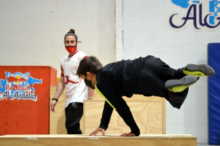 Un joven realiza ejercicios de parkou bajo la mirada de un monitor en las instalaciones de la Federación Andaluza de Gimnasia en Albolote (J. PALMA)