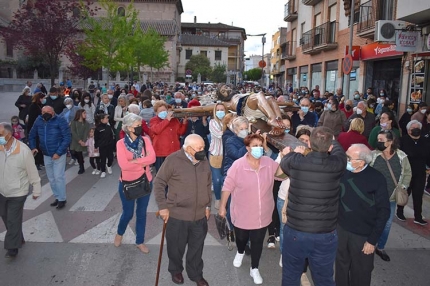 El Cristo es llevado a hombros por la Plaza de España. Abajo, la imagen de pie frente al lugar donde perecieron las tres víctimas del terremoto.