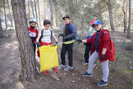 Alumnado de los centros escolares a la salida desde la plaza del Ayuntamiento. Abajo, reparto de plantones en la sierra.