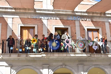 Mujeres de las asociaciones de Albolote decoran el balcón del Ayuntamiento. Abajo, decoración en una calle de la localidad.
