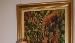 La pintora, Elvira Martín, posa junto a uno de sus cuadros