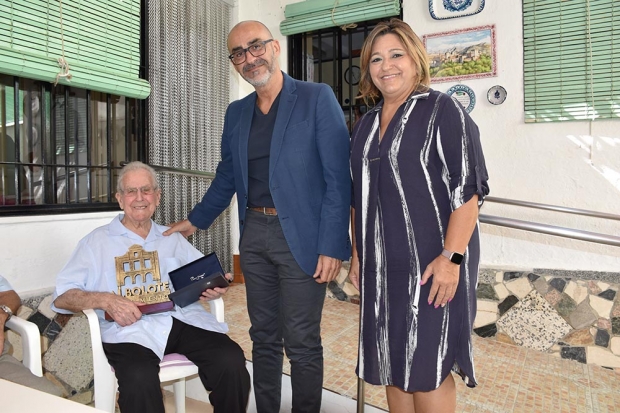 Pepe García recoge el reconocimiento a su trabajo de manos del alcalde y de la concejala de Mayores. Abajo, junto a su hermano Pedro, de 87 años.