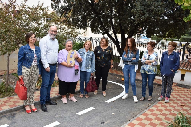 La presidenta de Amefa, Mª del Mar Sánchez, muestra la escultura de la mariposa rodeada de concejales y mujeres de Amefa.