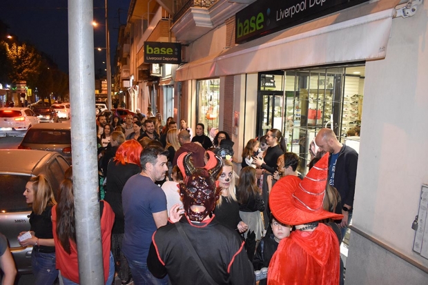 Un amplio grupo de participantes en la fiesta se agolpa a las puertas de un local de Albolote. Abajo, uno de los talleres organizado por Cruz Roja.