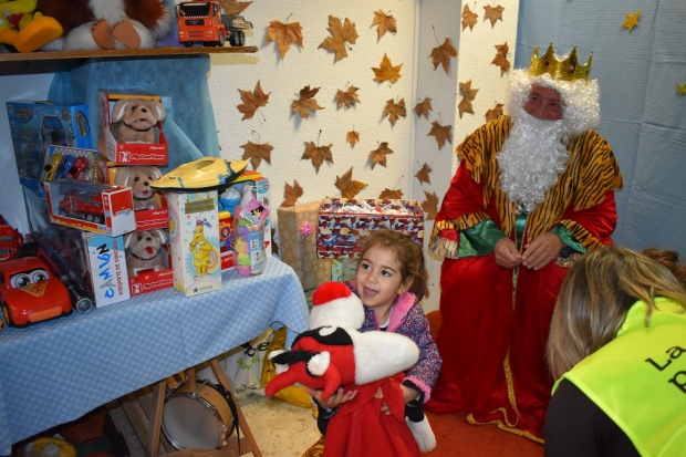 Una niña recibe un regalo de Reyes de la asociación 