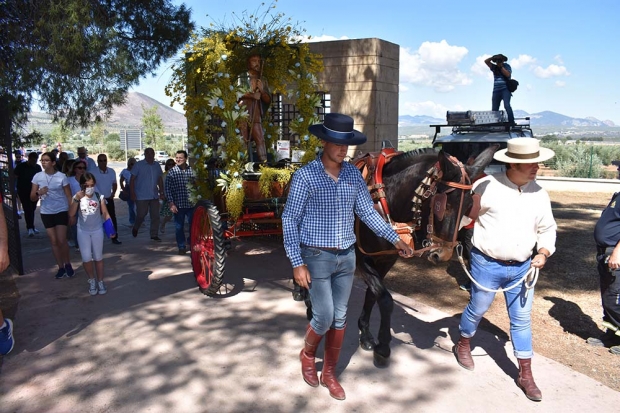 La imagen de San Isidro Labrador en su carroza entra al recinto de Los Pinos. Abajo, un momento de la misa romera oficiada por el párroco Juan Enrique Guerra.