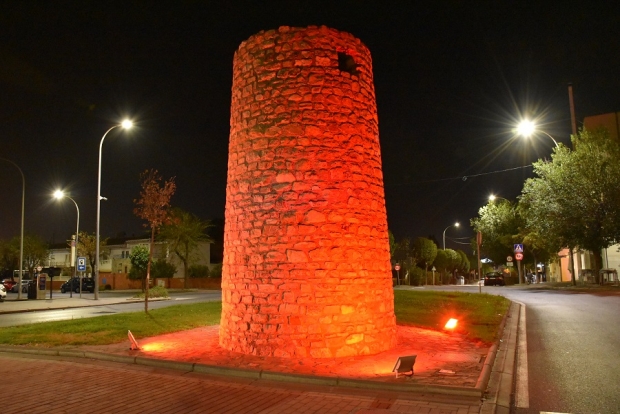 Torreón iluminado de rojo para dar visibilidad a la enfermedad
