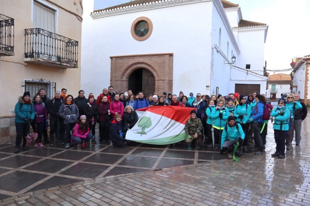 El grupo posa con la bandera de Albolote a la salida desde la Plaza de la Iglesia de Alquife