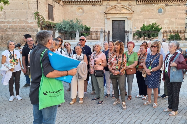 Parte del grupo atiendo las explicaciones del guía a su paso por la Plaza del Ayuntamiento
