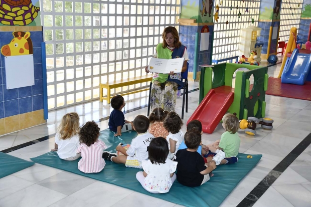 Una maestra cuenta un cuento a pequeños de dos años en la escuela infantil El Parque. Abajo, un grupo de pequeños juega en una casita de la escuela La Encina de El Chaparral.