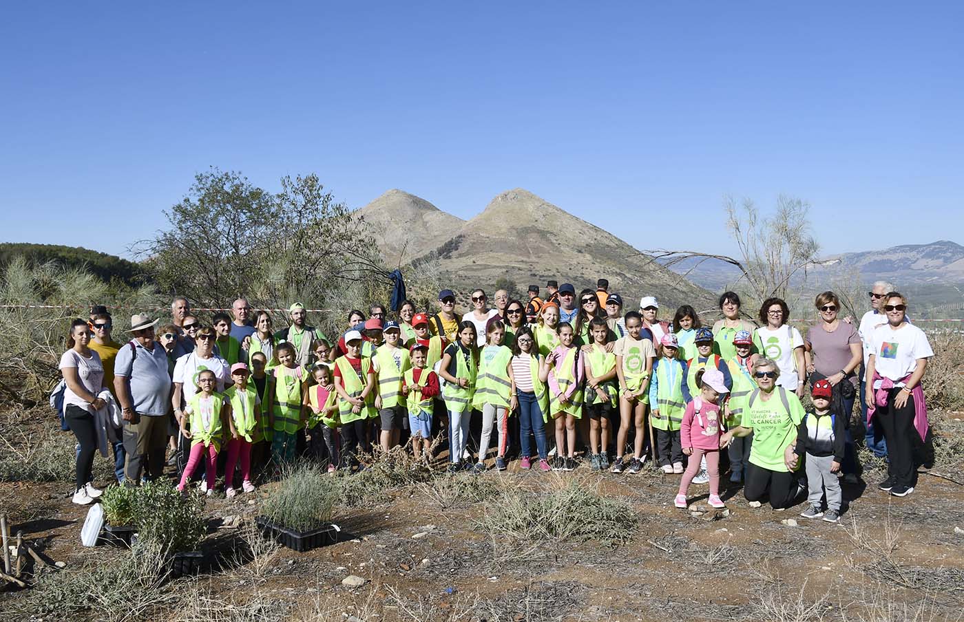 Niños y adultos participantes en una nueva edición del Día del Árbol. Abajo, una monitora asesora a un niño durante la plantación. Niños y adultos participantes en una nueva edición del Día del Árbol. Abajo, una monitora asesora a un niño durante la plantación.