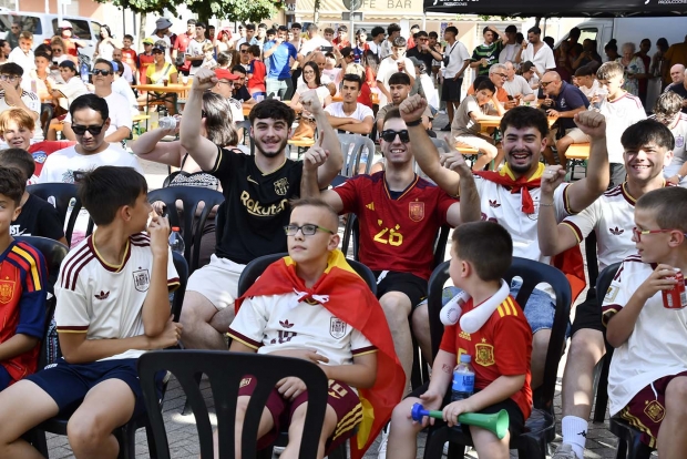 Jóvenes aficionados de Albolote celebran uno de los goles de la selección española en la plaza del Ayuntamiento.